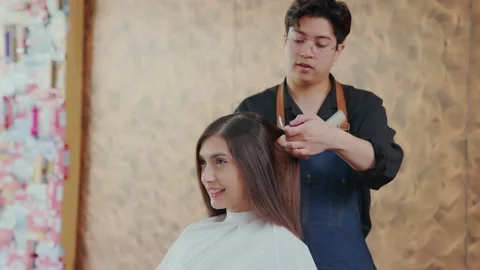 Slow motion. Pretty young client in a barber shop sitting and professional ba Stock Footage 153962304
