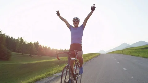 SLOW MOTION: Pro cyclist cheerfully rides road bike with no hands after victory. Stock Footage 86876963