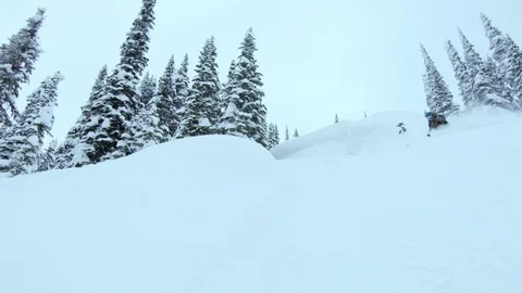 Slow motion of pro skier in red suit skiing on steep snowy hill, Red Mountain Stock Footage 129095937