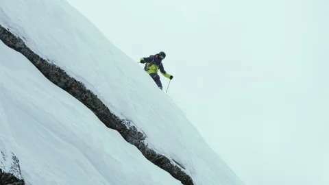 Slow motion of pro skier sliding down extremely steep snowy hill, Red Mountain Stock Footage 129096502