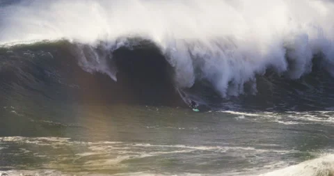 Slow motion of pro surfer riding down huge barrel wave before it closes on him Stock Footage 155669546