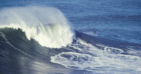 Slow motion of pro surfer surfing away from big ocean wave picking up height Stock Footage 155797159