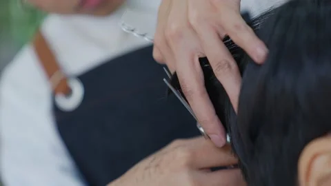 Slow motion. Professional barber uses scissors to cut hair and style hair for Stock Footage 153820840