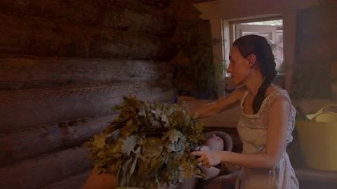 Slow motion of professional bath attendant over body of sauna visitor Stock Footage 221943286