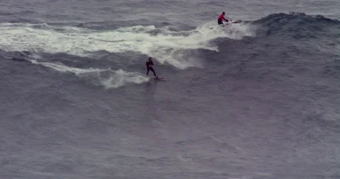 Slow motion of professional surfer being carried by jet ski with another surfer Stock Footage 156136102