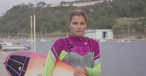 Slow motion professional surfer Maya Gabiera posing with colorful surfing board Stock Footage 157133555