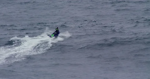Slow motion of professional surfer sitting down on jet ski in middle of ocean Stock Footage 156131075