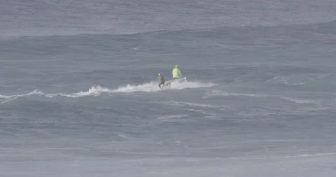 Slow motion of professional surfer strapped behind jet ski of surfer in ocean Stock Footage 160104965
