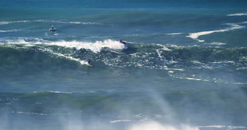 Slow motion of professional surfer using jet ski to ride smaller ocean waves Stock Footage 155800929