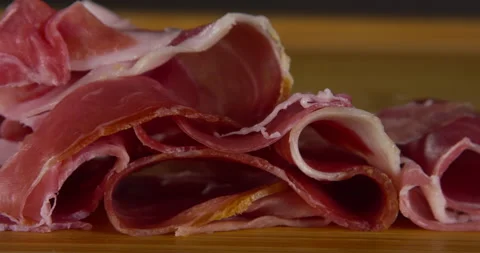 Slow motion prosciutto falling on wood cutting board Stock Footage 133965902