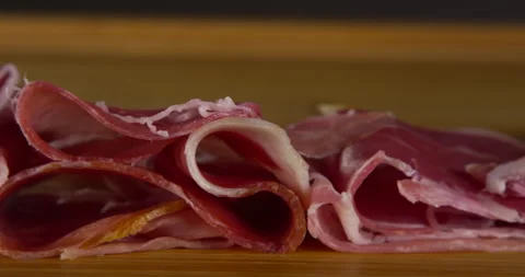 Slow motion prosciutto falling on wood cutting board Stock Footage 133965955