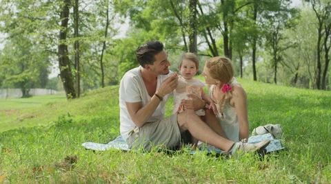 SLOW MOTION: Proud daddy and mummy watching first steps of their baby girl Stock Footage