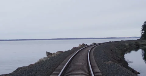 Slow motion push with DJI Ronin across railroad tracks on Northwest bay Stock Footage 57705939