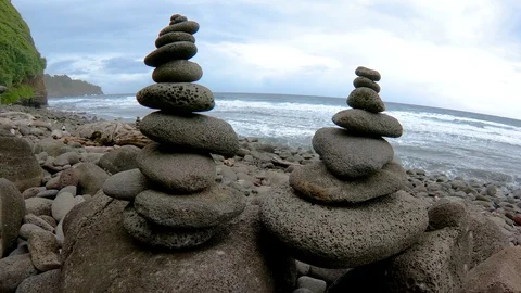 Slow motion push thorugh two cairns on stony beach at Pololū Valley Hawaii 4K Stock-Footage 98426010