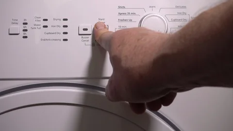 Slow motion: Pushing buttons to start a tumble drier. Stock-Footage 95929101