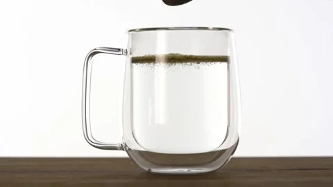 Slow motion of putting instant tea in a glass cup with hot water Video stock 144431504
