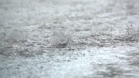 Slow motion rain droplets falling on ground on blurred background Vídeo Stock 93518980