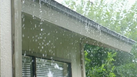 Slow motion rain droplets falling on house roof Stock Footage
