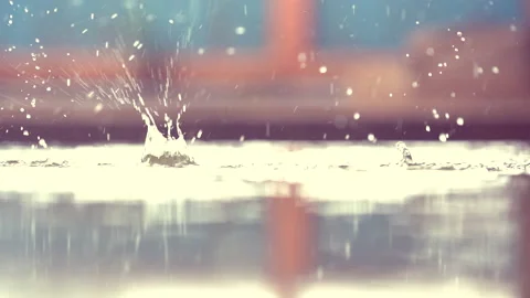 Slow motion rain droplets falling on ground on blurred background 스톡 동영상 140121958