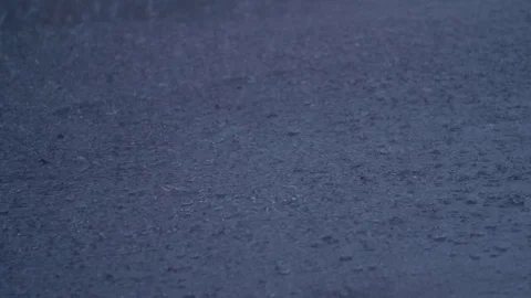 Slow Motion Rain Drops Falling on Assfault Road Stock Footage 79786540