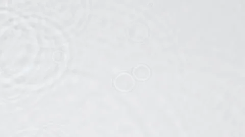 Slow motion rain drops on water surface over grey abstract background, top view. 動画素材 207960432