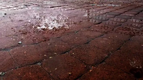 Slow motion rain falling on pavement tiles, close-up shot with water drops Stock Footage 339323098