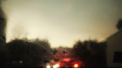 Slow motion rain flows and wipers on the front windshield glass window of car on Stock Footage 94531493