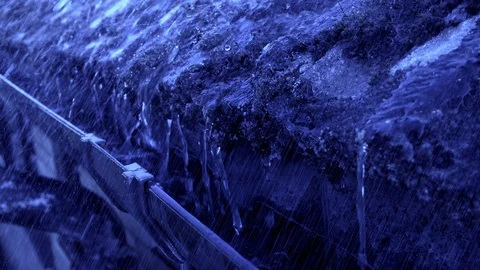 Slow motion – Rain in moonlight pouring off a tiled roof into the gutter below. Stock-Footage 129218037
