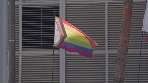 Slow motion of rainbow flag blowing in wind in downtown Seoul Stock Footage 313837991
