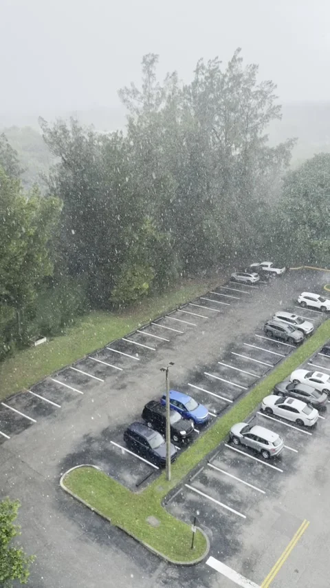 Slow Motion Raindrops Fall Over a Flooded-Looking Parking Lot During Miami H Stock Footage 342204009