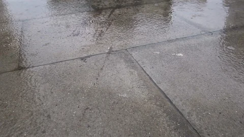 Slow motion raindrops fall in puddles on the wet sidewalk Stock Footage 118993421
