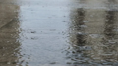 Slow motion raindrops falling on puddles during a heavy rainstorm Stock Footage 118993372