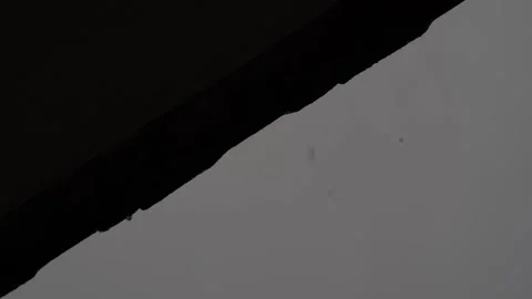 Slow-Motion Raindrops Falling from Rooftop, Showcasing the Grace of Rainfall Video stock 295970155