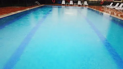 Slow motion. Raindrops on surface of water in pool. Close-up. Stock Footage 133708031