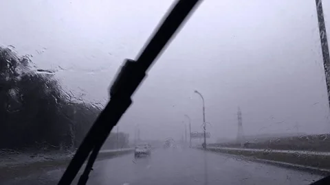 Slow motion. Raindrops washes away windshield wiper of car on cloudy rainy day Stock Footage 168618568