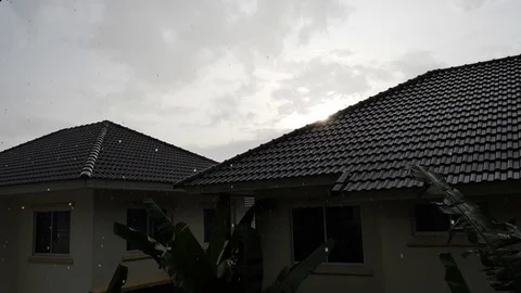 Slow motion rainy day sunset scene, water pouring rain falling on roof house Stock Footage 92644099