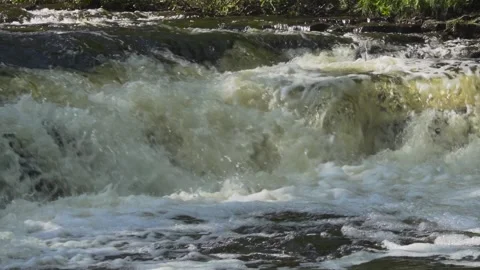 Slow motion of rapid river water over rocks Stock Footage 166597361