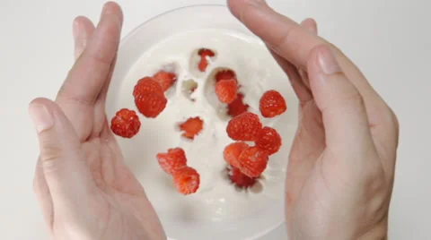 SLOW MOTION: Raspberries falls from a human hands to the milk in a dish Vídeos de archivo 65173045