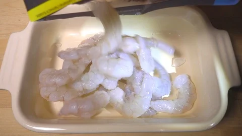 Slow motion –  Raw king prawns being tipped into a dish. Stock Footage 101291990