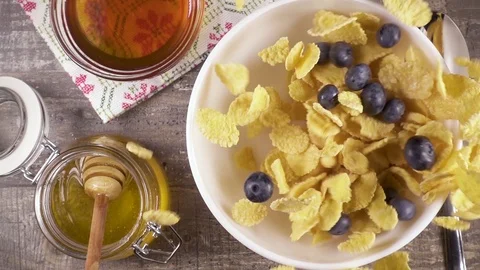 Slow motion ready breakfast with milk, honey and berries top view Stock Footage 92950387