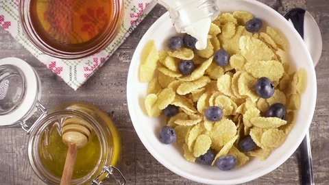 Slow motion ready breakfast with milk, honey and berries top view Stock Footage 92950535