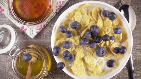Slow motion ready breakfast with milk, honey and berries top view Stock Footage 92950696