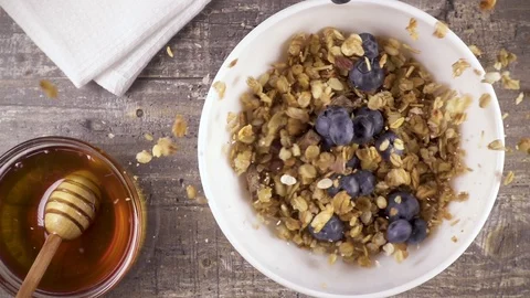 Slow motion ready breakfast with milk, honey and berries top view Stock Footage 92951271
