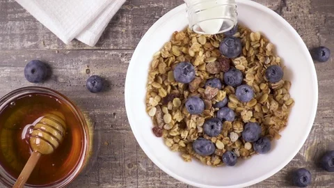 Slow motion ready breakfast with milk, honey and berries top view Stock-Footage 92951503
