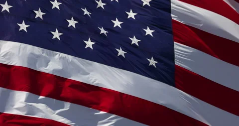 Slow Motion Real American Flag Waving In Wind Against a Deep Blue Sky Stock Footage 156268041