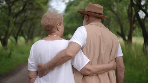 Slow motion. Rear view. Older married couple hugging while standing in a city Vídeos de archivo 273741554
