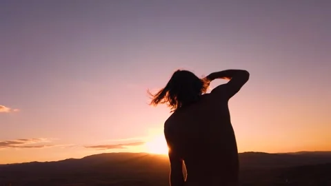 Slow motion rear view of shirtless man silhouette dancing at sunset Stock Footage 346742951