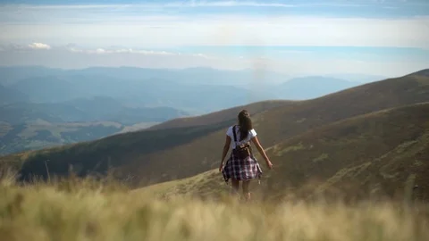 Slow-motion rear view young woman tourist hiking mountains enjoy beautiful Stock Footage 110816431