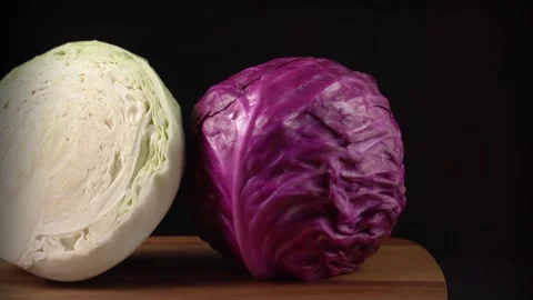 Slow motion of red cabbage and white cabbage on a wooden cutting board Stock Footage 132034035