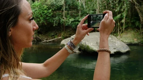Slow motion, Red Camera: Female Traveller takes photos of beautiful creek using  Vídeos de archivo 114419305
